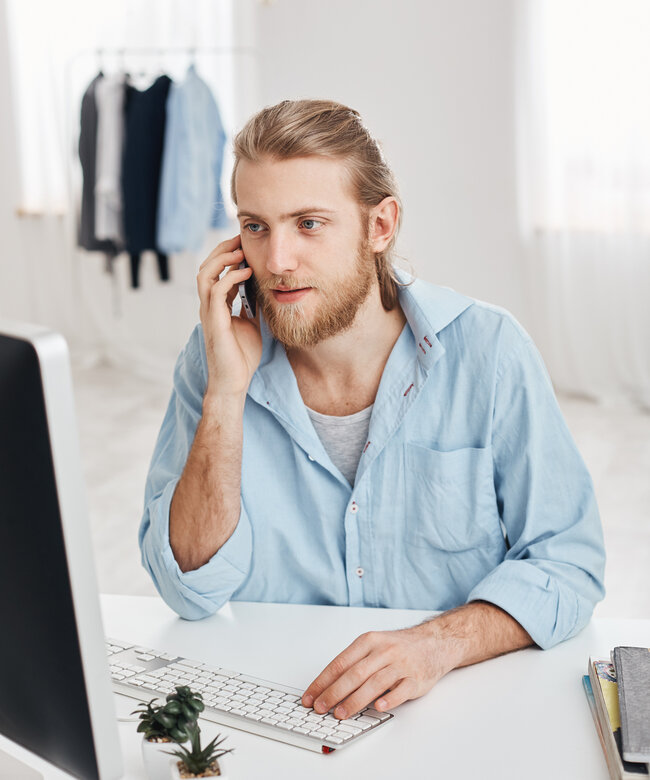 E-Commerce Manager betreut Kunden und digitale Verkaufsprozesse im Online-Handel E-Commerce Manager führt ein Telefongespräch mit Kunden und arbeitet am Computer im Online-Handel