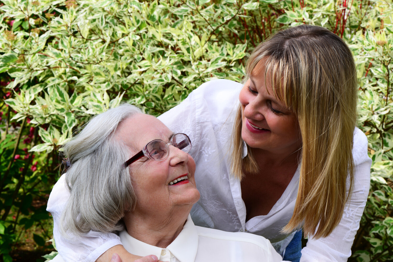 Quereinstieg Pflege – Arbeit in Betreuung und Begleitung Betreuungskraft im Gespräch mit einer Seniorin im Garten