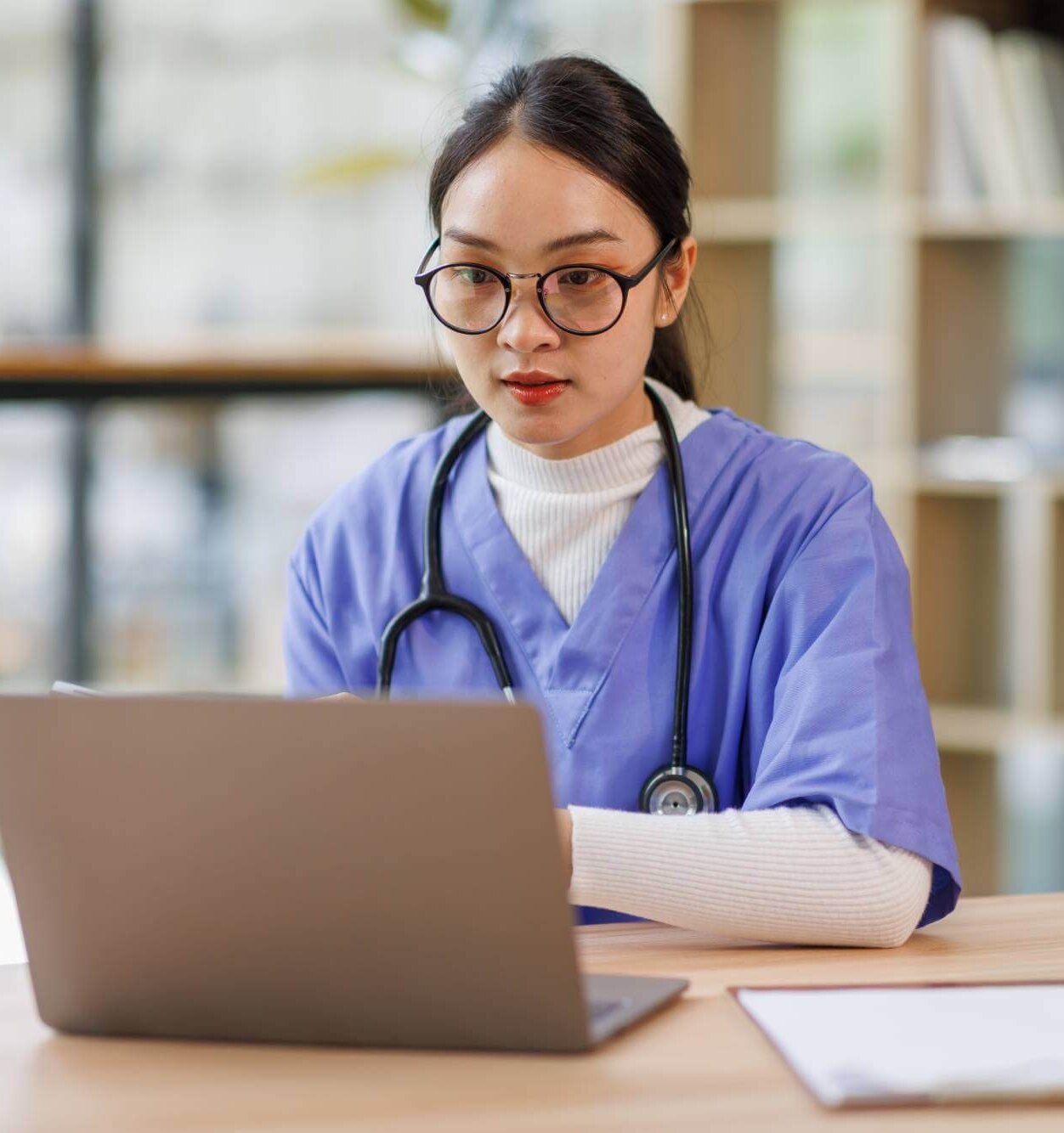 Weiterbildung im Gesundheitswesen – Grone Online Akademie Person arbeitet am Laptop mit digitalen Prozessgrafiken – Technologien und Management im digitalen Umfeld